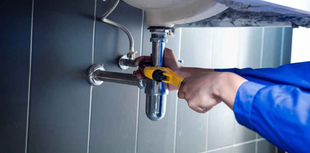 Plumber Fixing White Sink Pipe